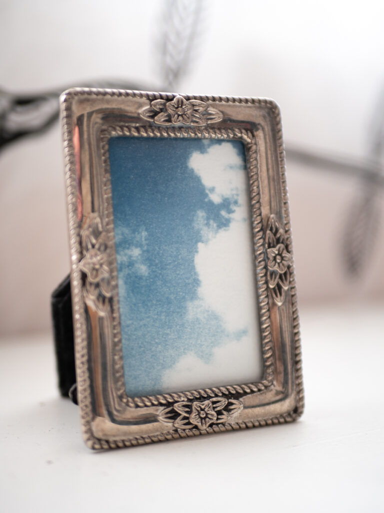Cyanotype dans son mini-cadre en métal argenté. La photo représente un ciel nuageux.