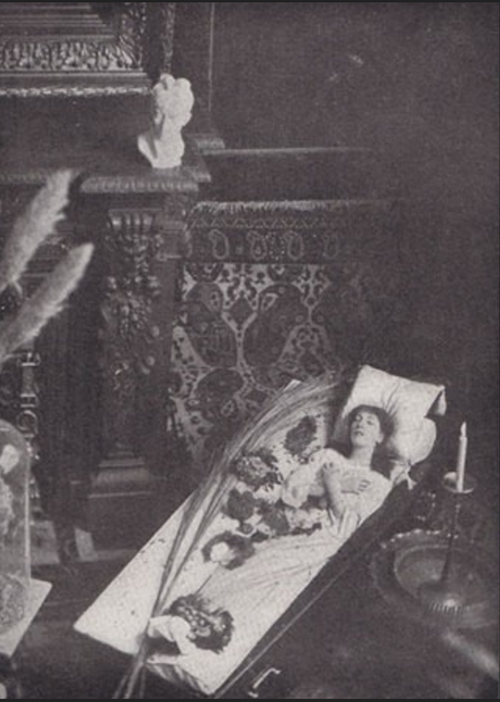 Sarah Bernhardt allongée dans un cercueil au milieu de son salon.